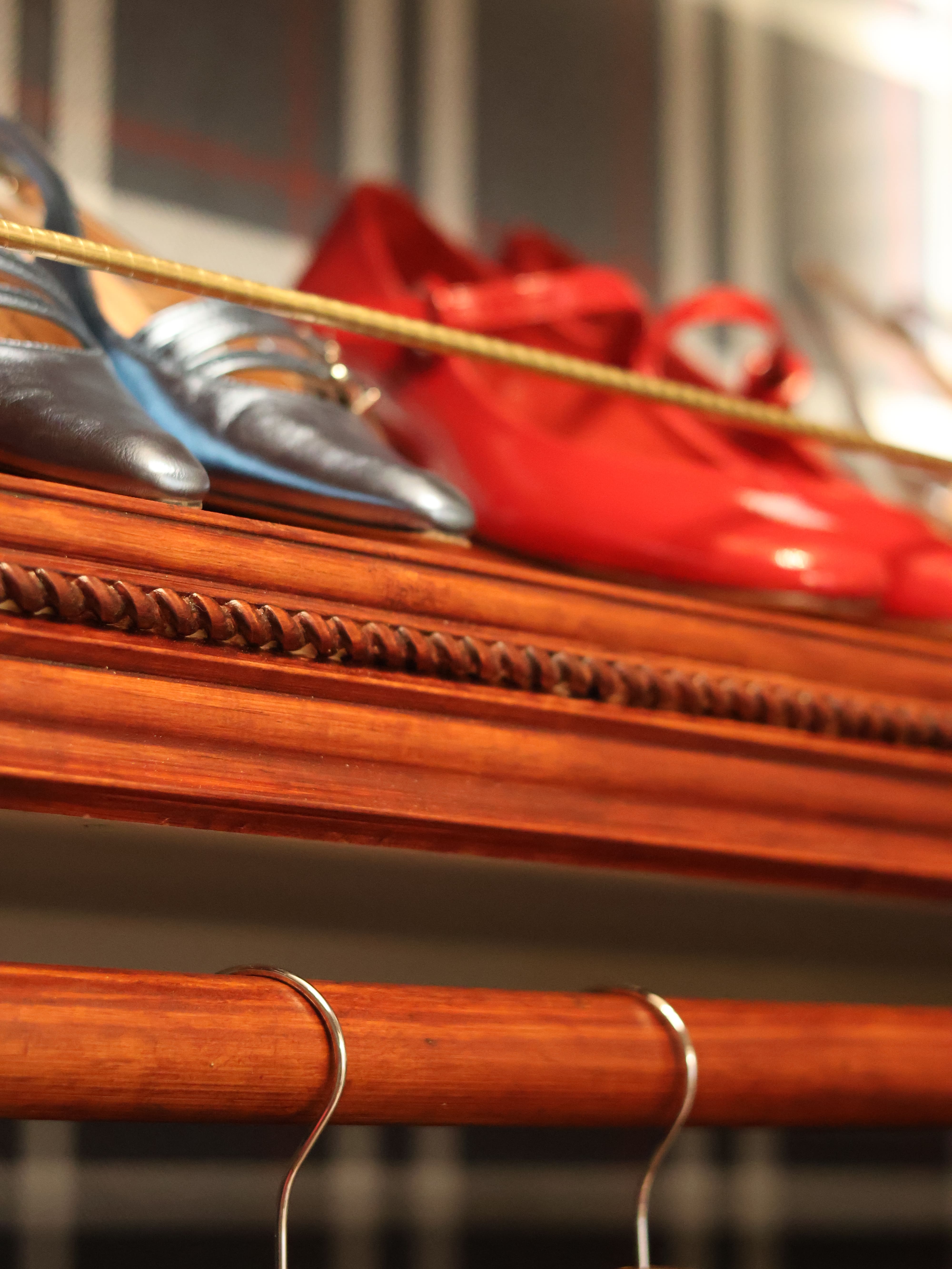 A close-up shot of shoes on wooden shelves in a newly renovated closet space.