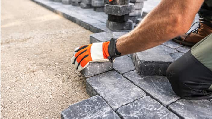 A Pro installs pavers in a patio.