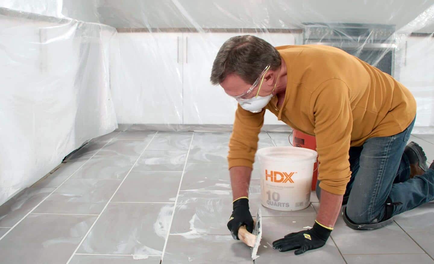 Person holds grout float at a 90-degree angle on a tile floor