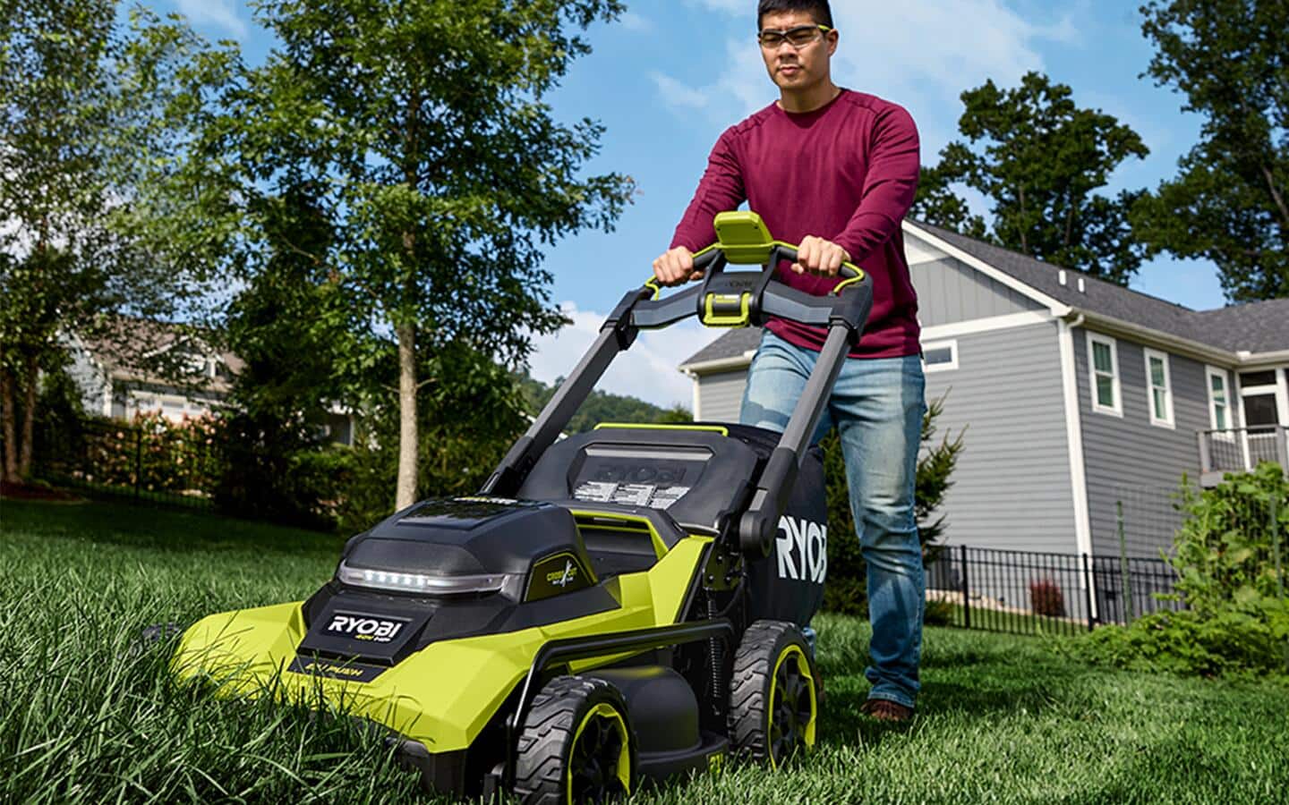 A person cutting grass with a push lawnmower.