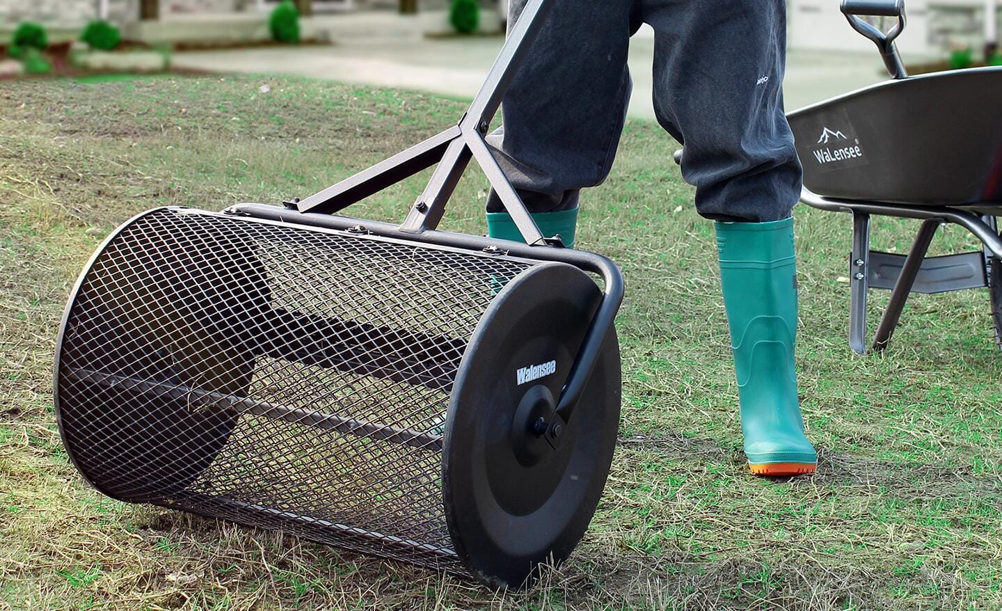Gardener pushing a compost spreader on a lawn