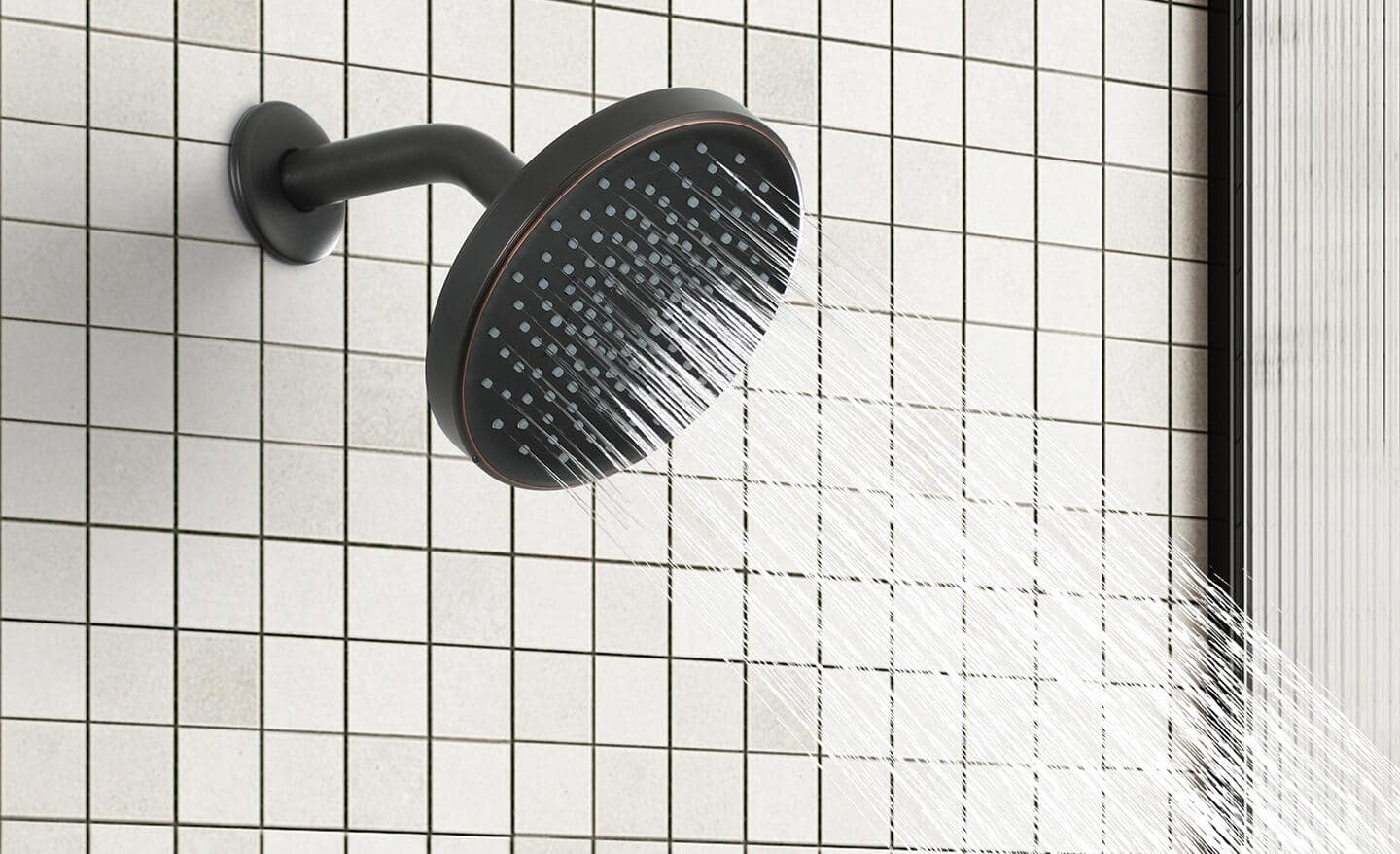 A fixed shower head spraying water into a shower.