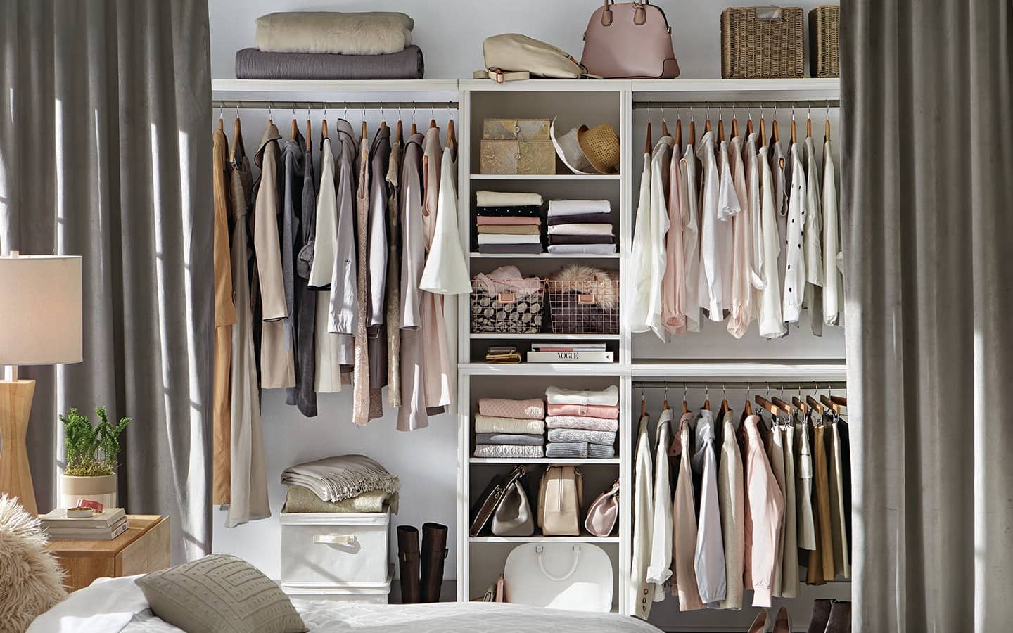 Curtains opened to show clothes hanging from rods and folded on white shelves. Curtains opened to show clothes hanging from rods and folded on white shelves.