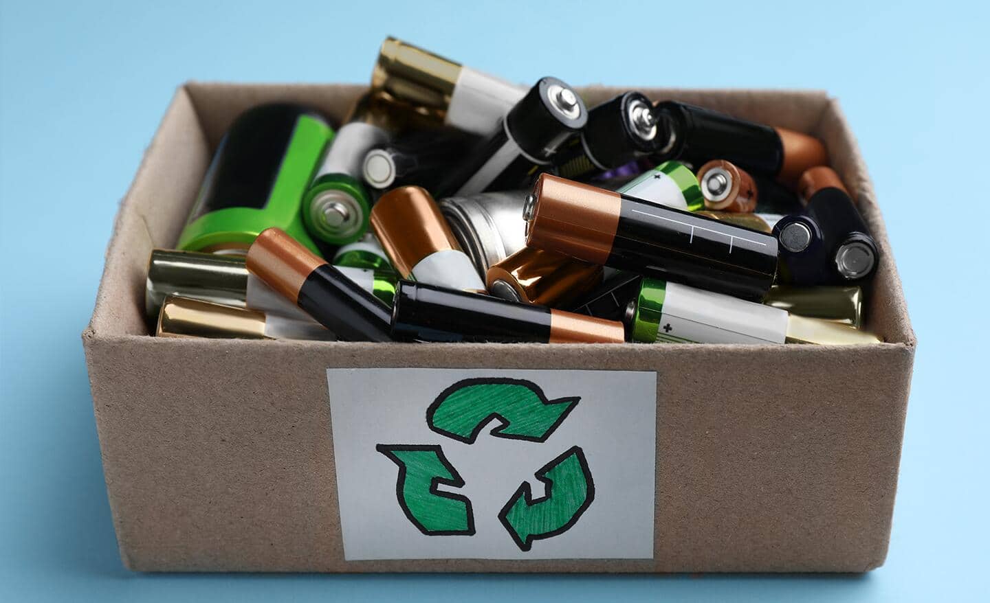 A cardboard recycling box full of used batteries.