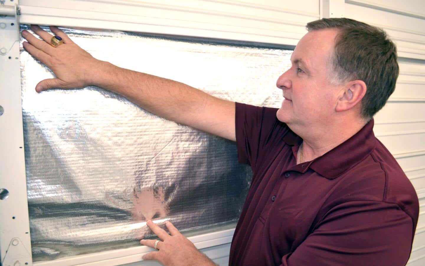 A man installs radiant barrier insulation. A man installs radiant barrier insulation.