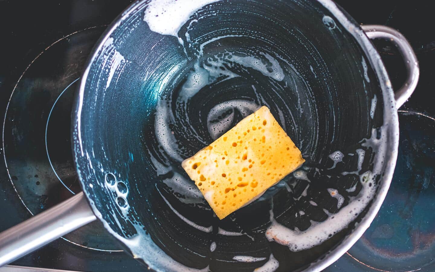 A soapy sponge sitting in the middle of a wok. A soapy sponge sitting in the middle of a wok.
