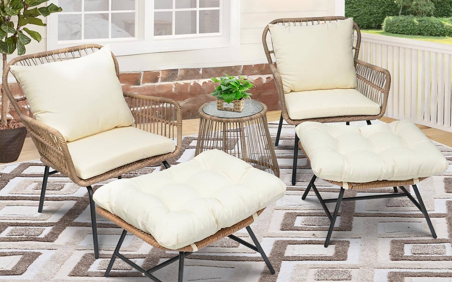 Two outdoor chairs with pull-out ottomans, all with white cushions, on a woven patio rug.