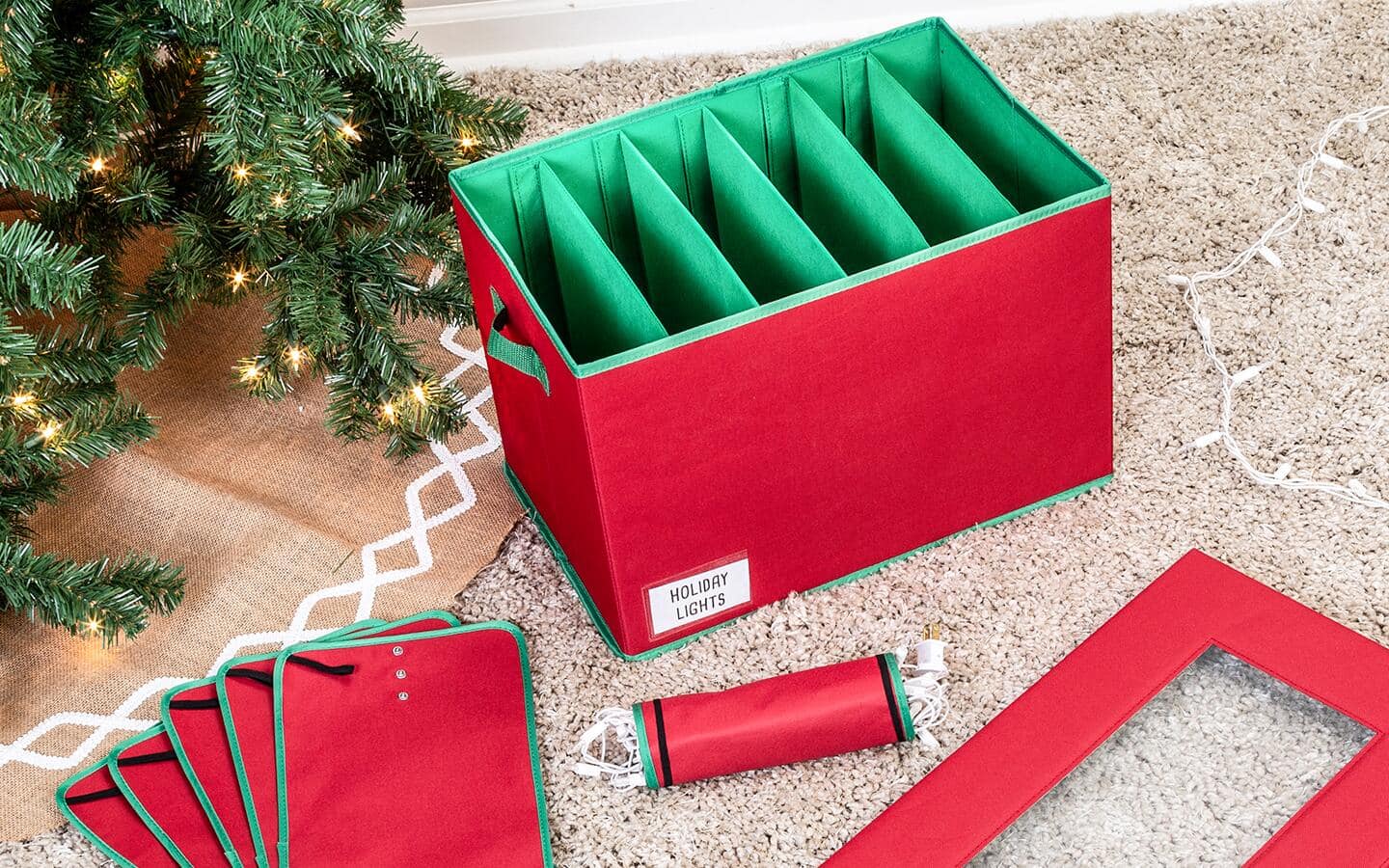 An empty holiday storage box placed next to a Christmas tree. An empty holiday storage box placed next to a Christmas tree.