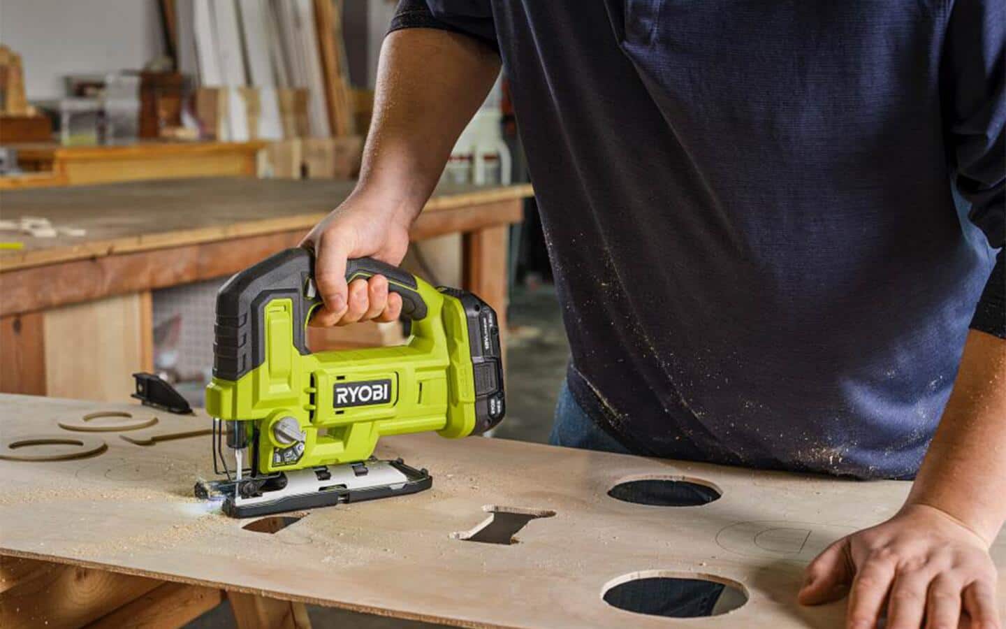 A D handle jigsaw is used to cut shapes in a piece of plywood. A D handle jigsaw is used to cut shapes in a piece of plywood.
