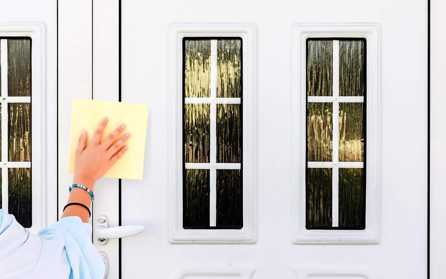 A person uses a cloth to clean a front door. A person uses a cloth to clean a front door.