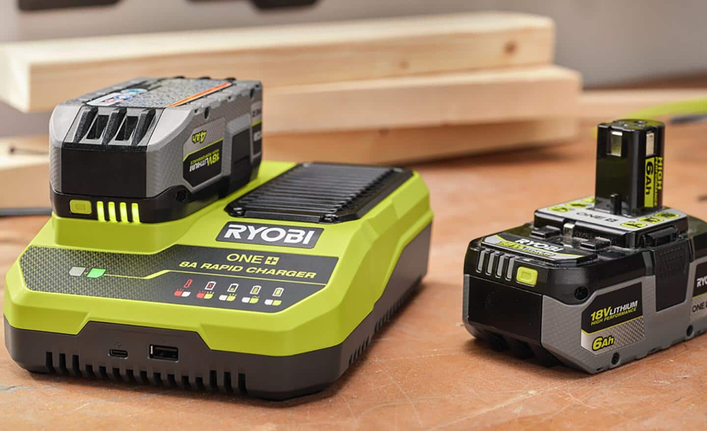 Two 18 volt batteries and a charger on a workbench.