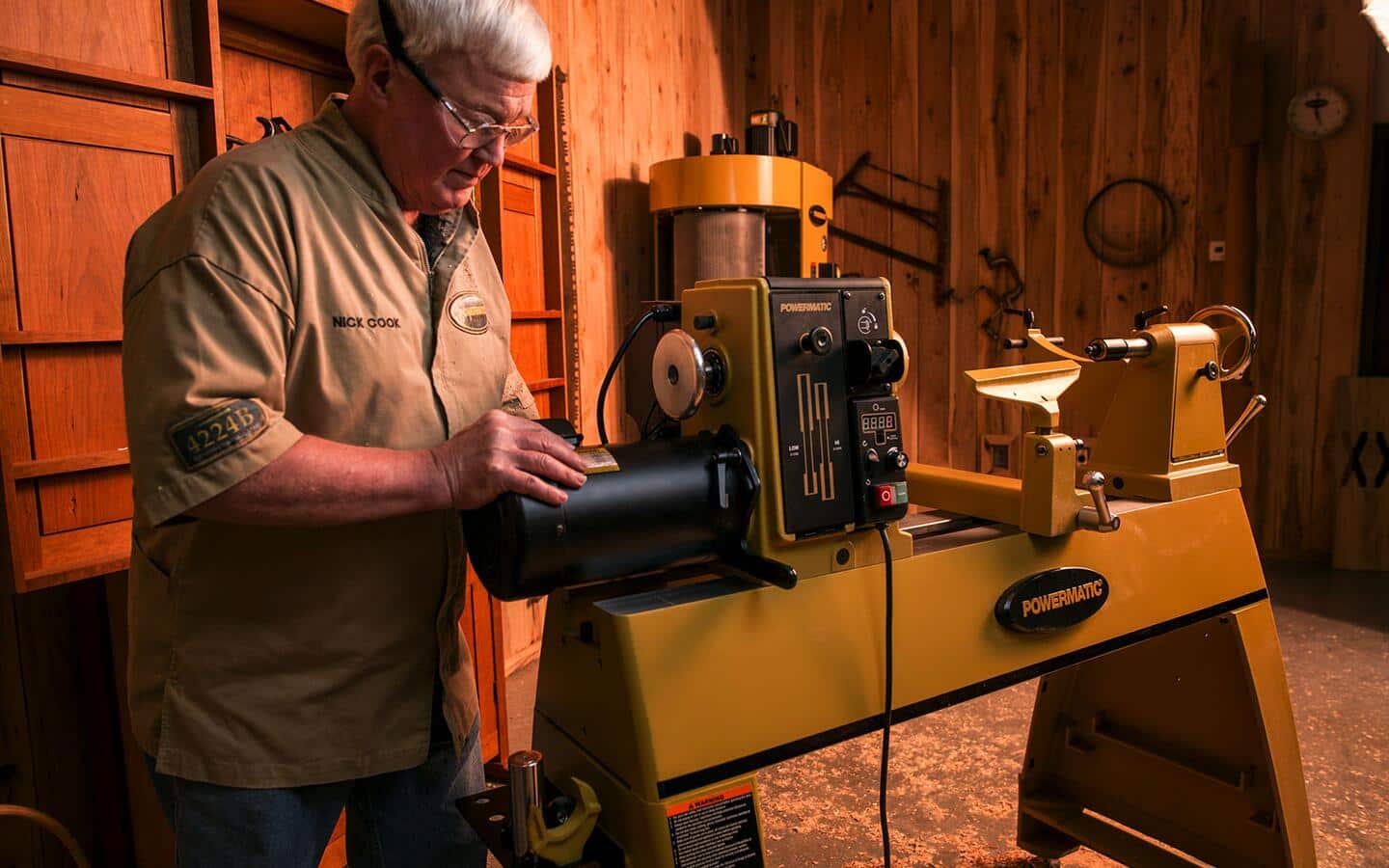 A man works with a lathe in a workshop. A man works with a lathe in a workshop.