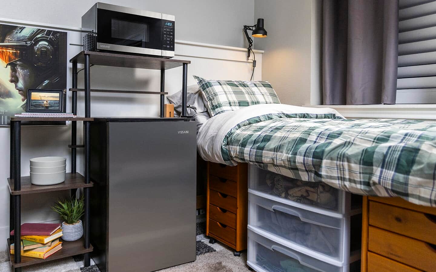 A mini fridge placed next to a bunkbed. A mini fridge placed next to a bunkbed.