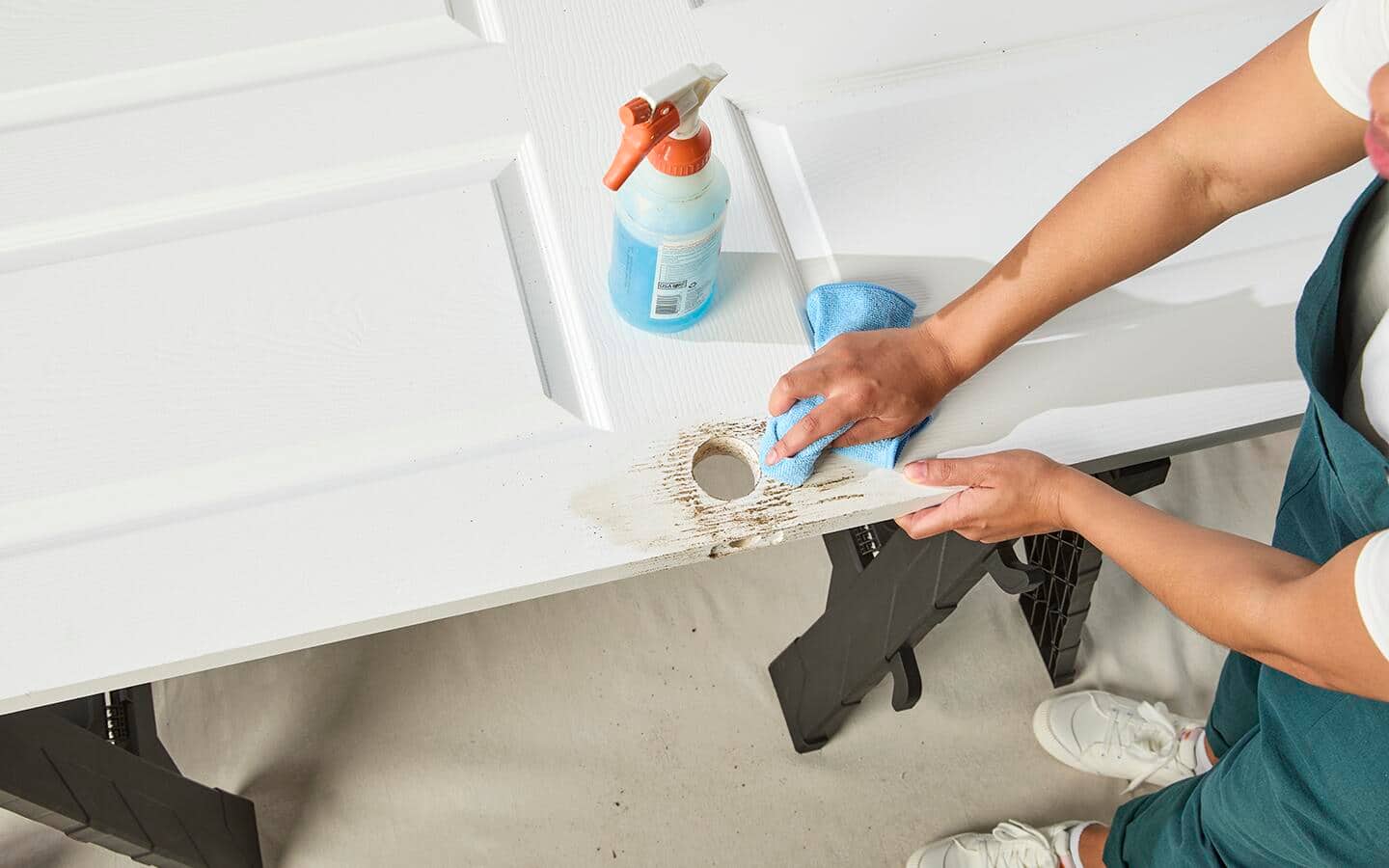 A woman cleans a door in preparation for painting. A woman cleans a door in preparation for painting.