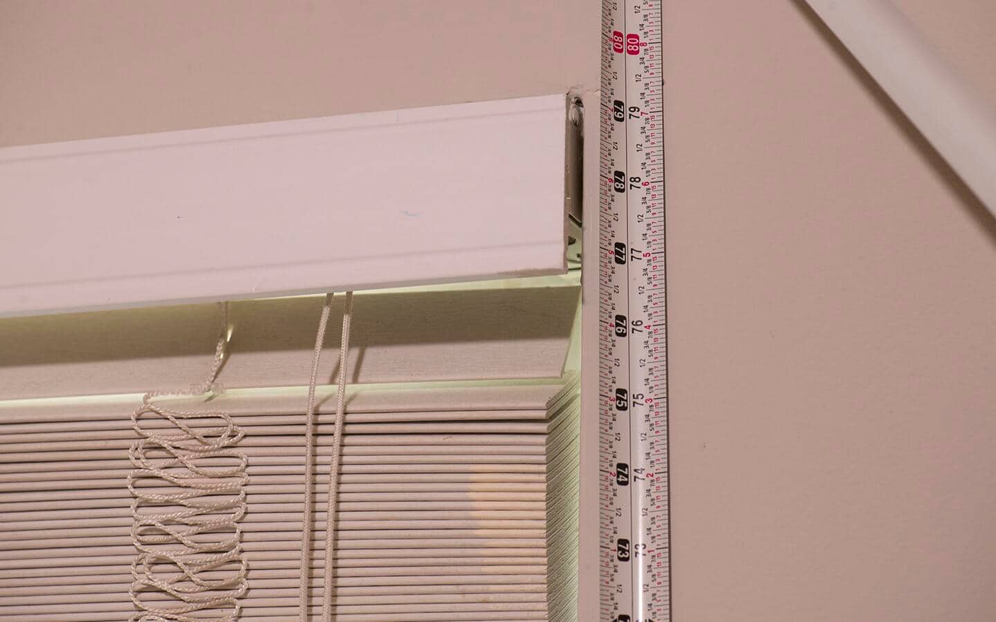 A tape measure is used to find the height of a window.