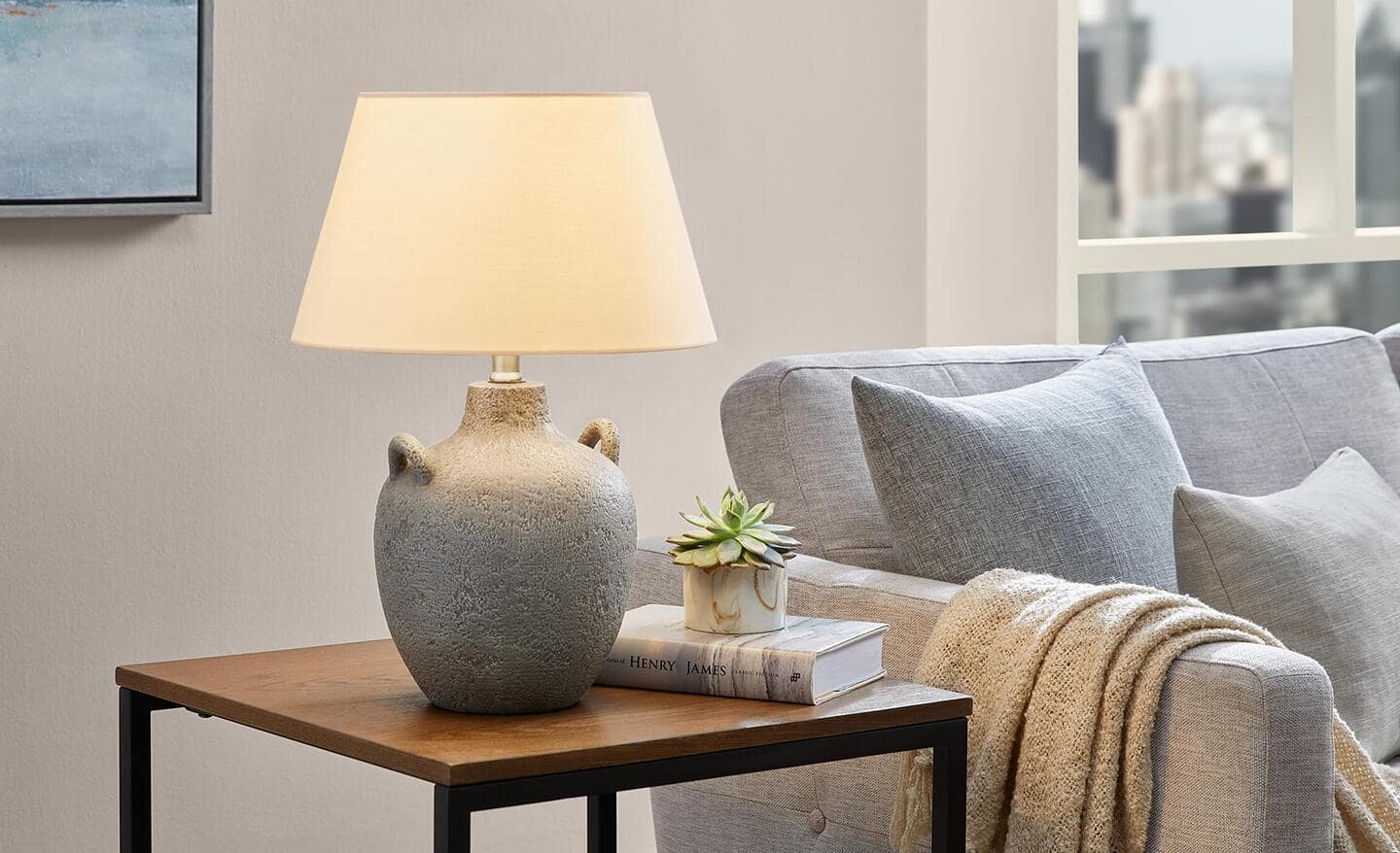 A table lamp sits on an end table next to a sofa.