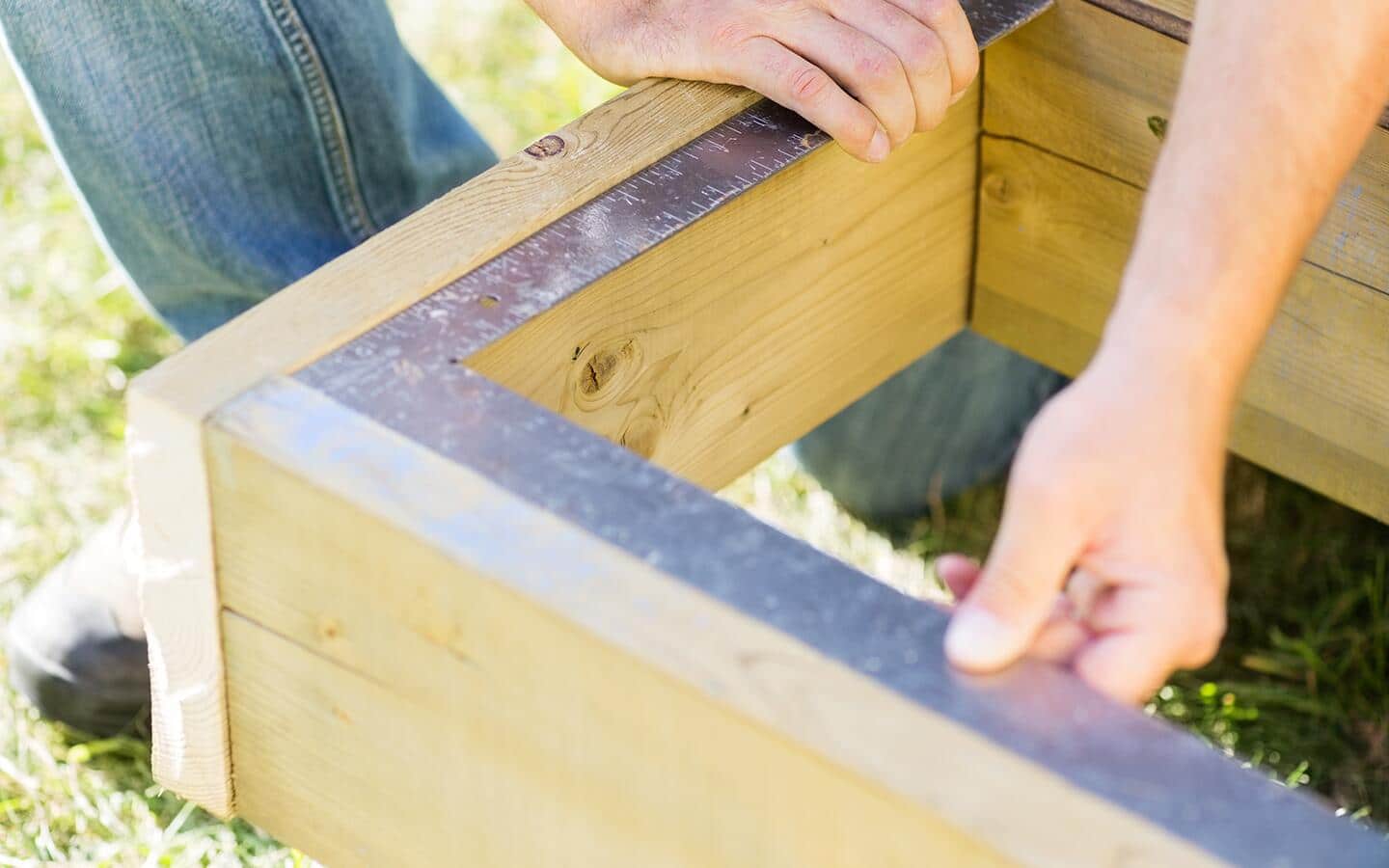 A person using a framing square. A person using a framing square.
