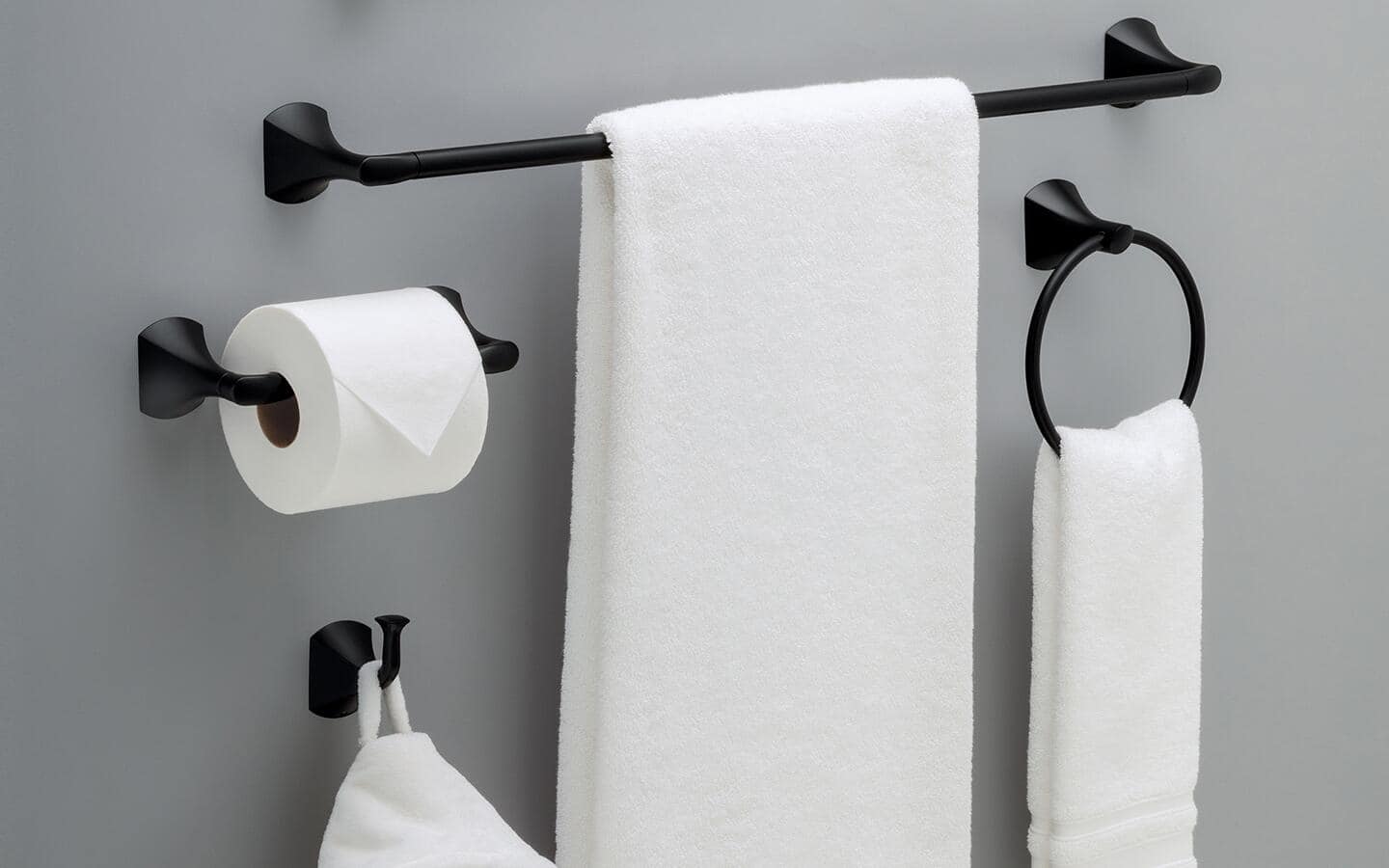 A black towel bar and other matching bath accessories hanging on a wall. A black towel bar and other matching bath accessories hanging on a wall.