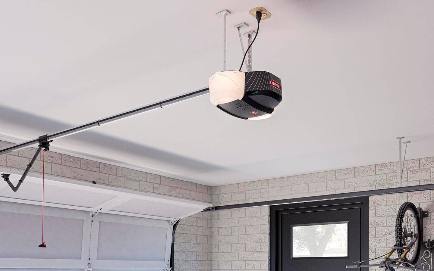 A belt drive garage door opener hangs from a ceiling.