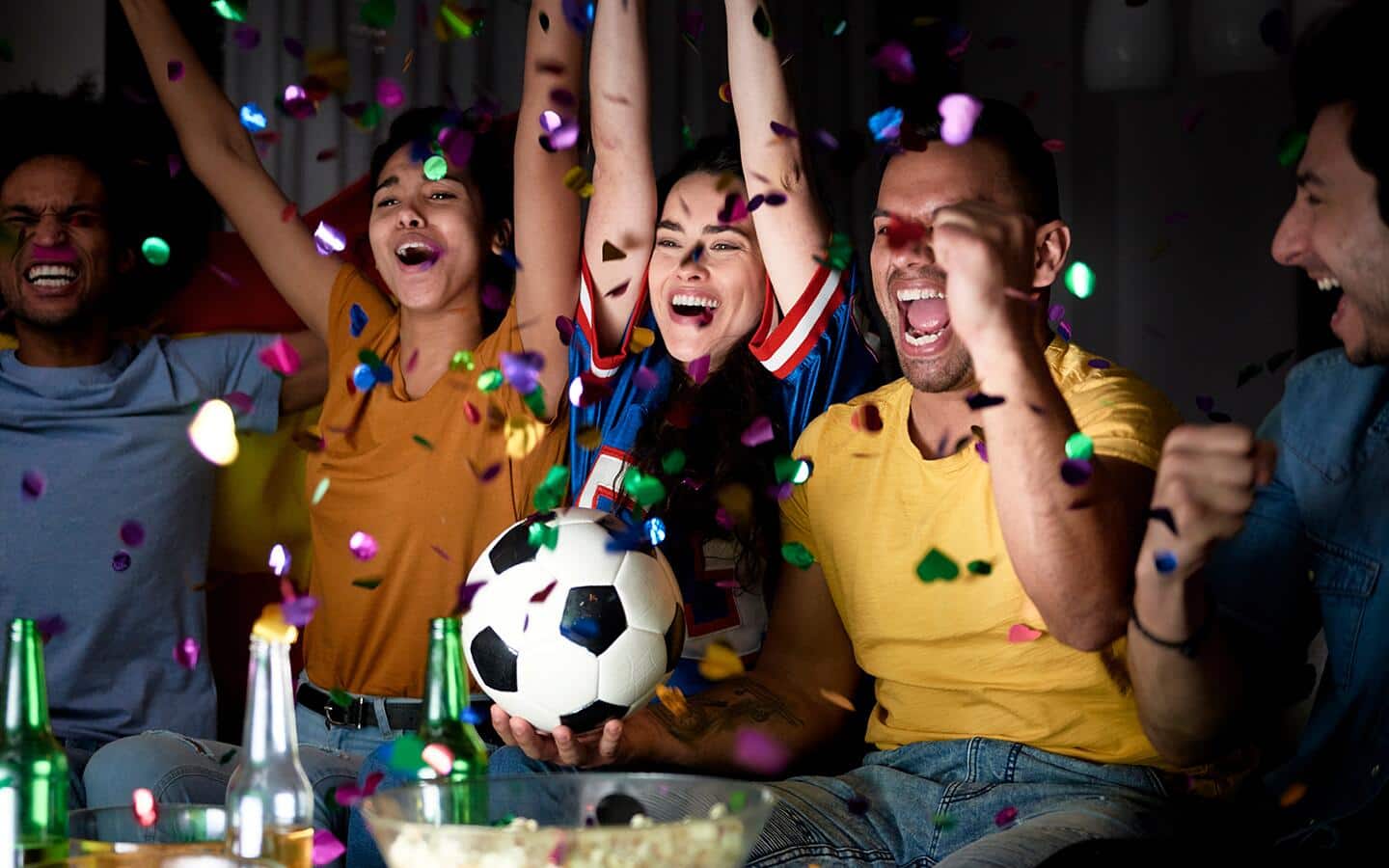 Confetti showers on enthusiastic soccer fans watching the game at home. Confetti showers on enthusiastic soccer fans watching the game at home.