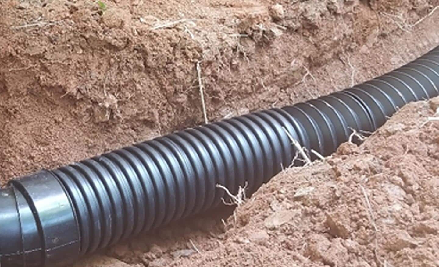 Corrugated drain pipe in a trench.