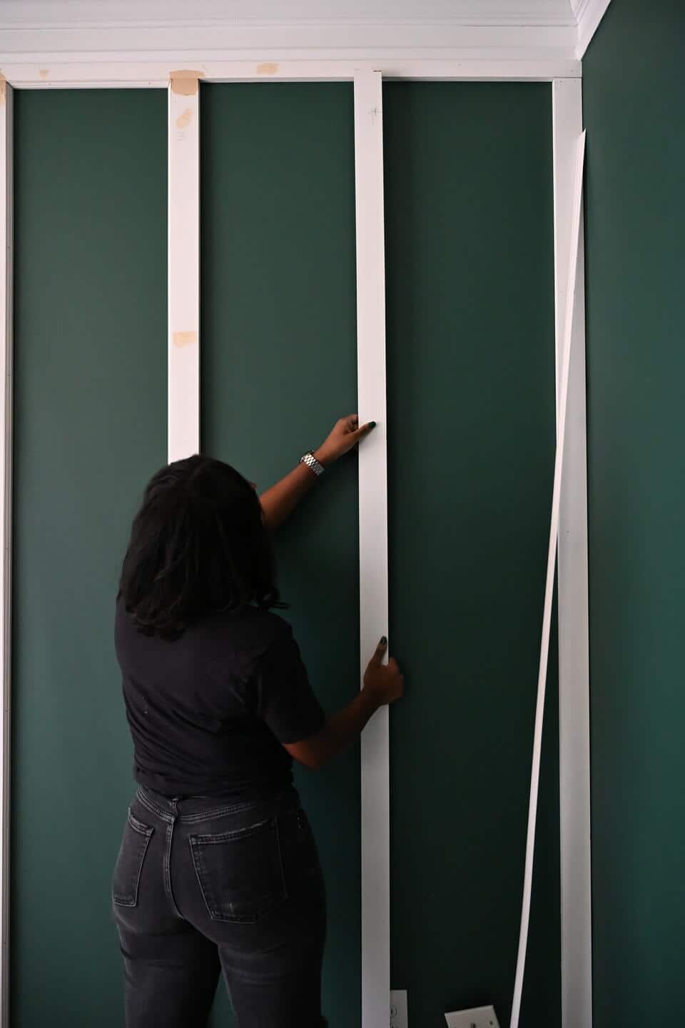Lauren working to install the wood wall boards to add texture to the walls in the office transfoamation. The boards are white, but will be painted green once the transformation is completed.