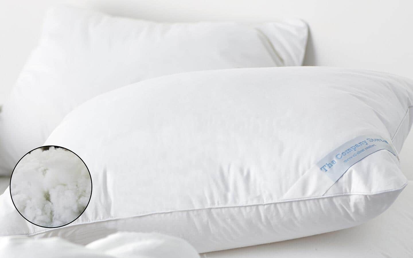 Two down alternative pillows stacked on a bed. Two down alternative pillows stacked on a bed.