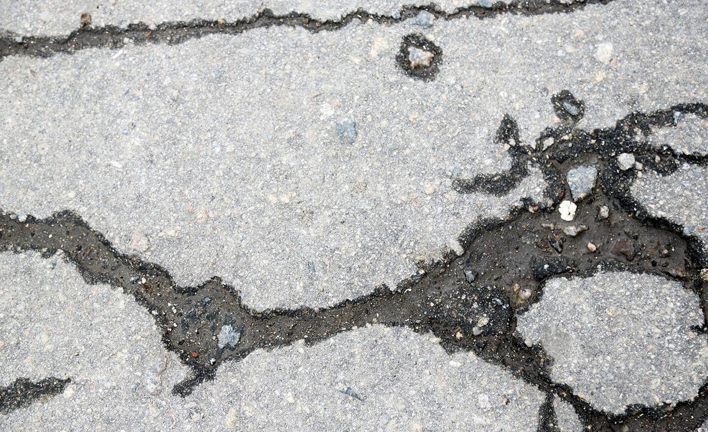 Large cracks in a concrete driveway.
