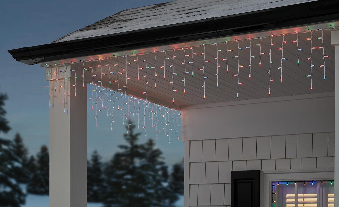 Multicolored icicle lights hanging on a house. Multicolored icicle lights hanging on a house.