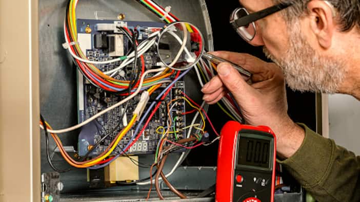 An electrician rewires a home’s electrical panel.