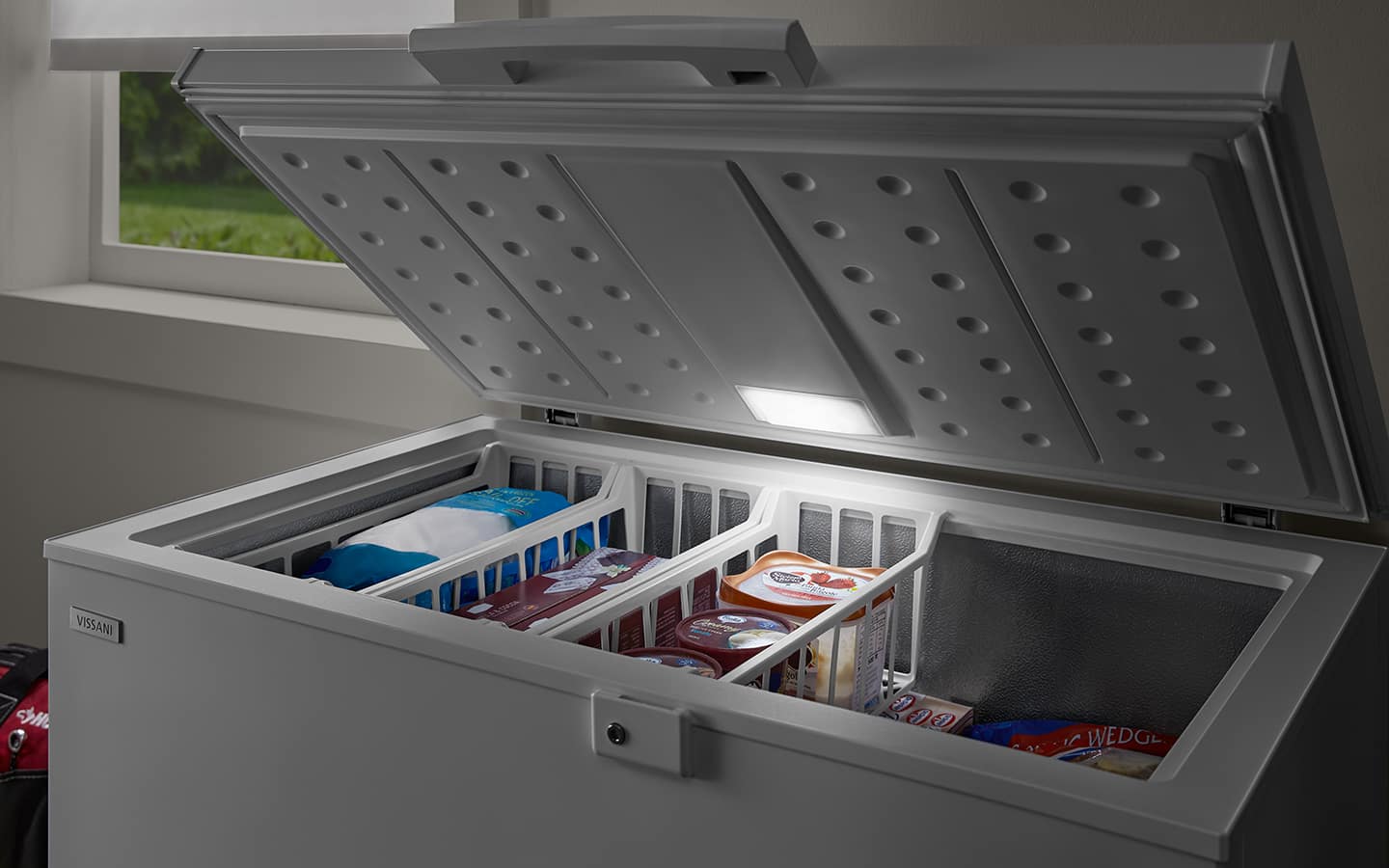 A light shining inside an open chest freezer.