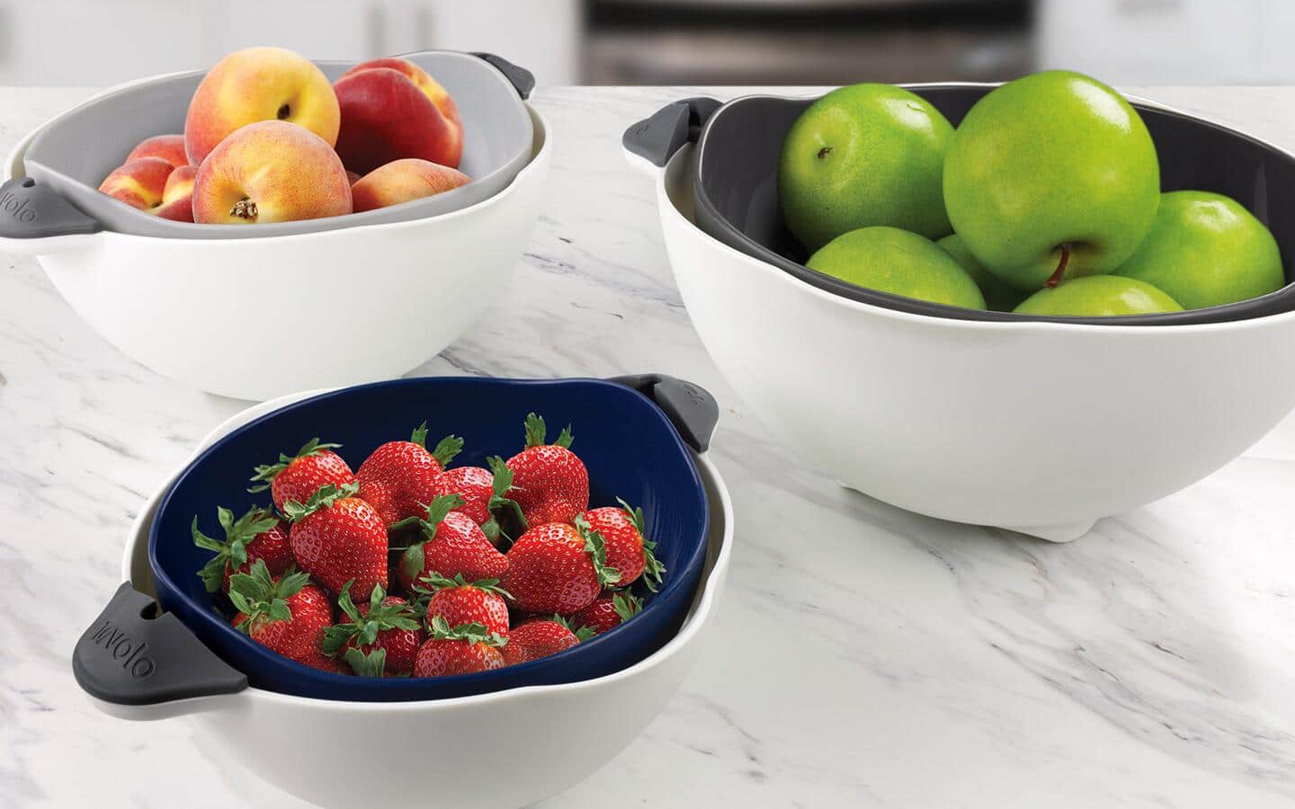 Mixing bowls in different shapes filled with fruit.