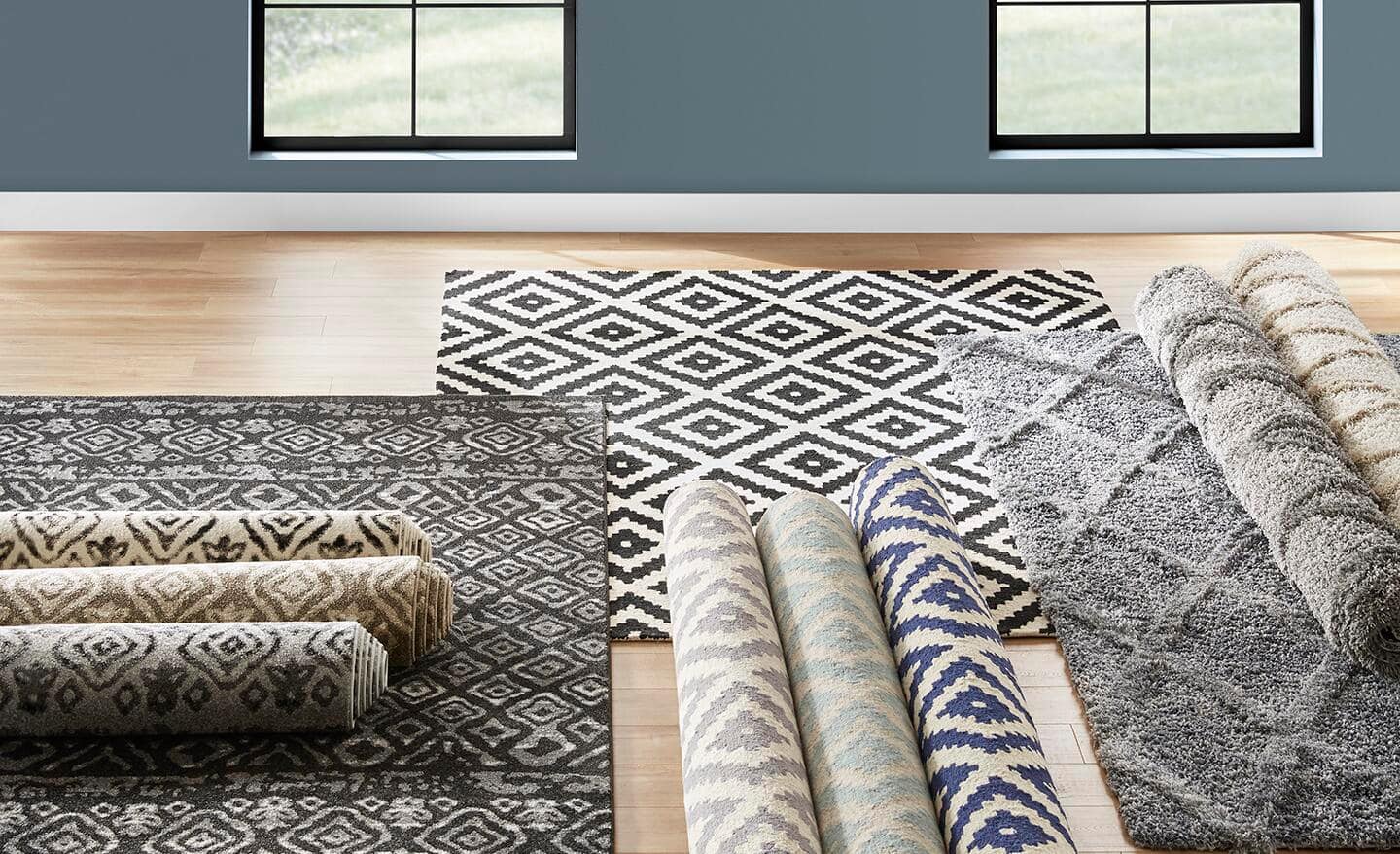 Different area rugs in multiple patterns laid out on the floor. 