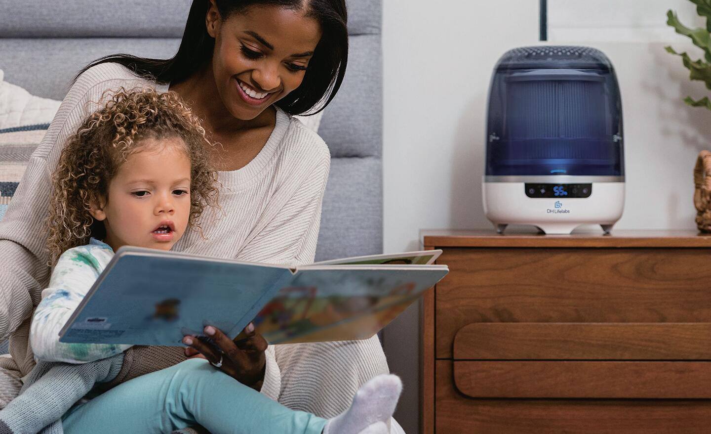 A woman using an air purifier in her daughter's bedroom.