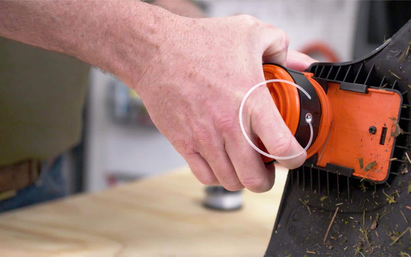 Someone replacing a grass trimmer head.