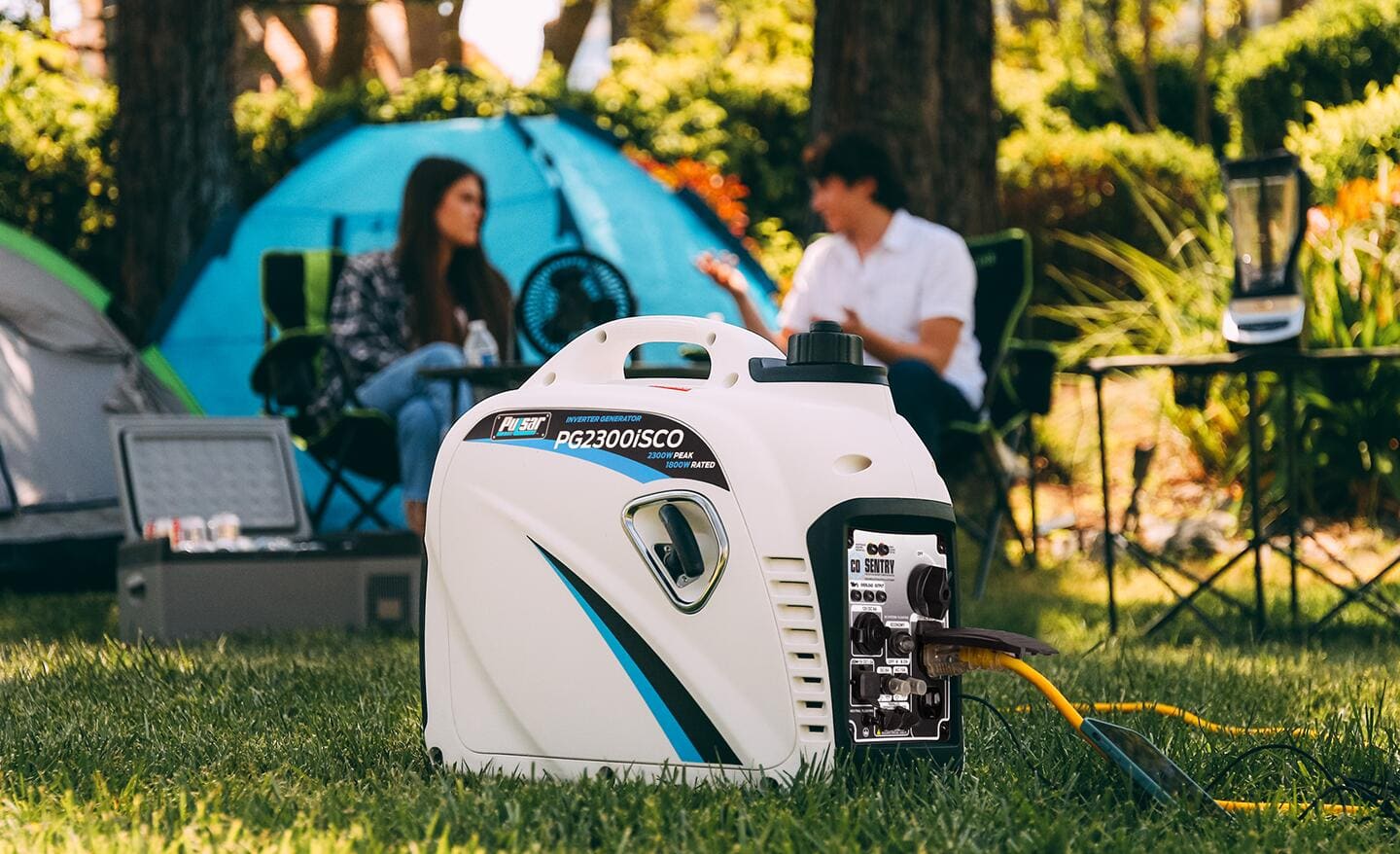 A portable generator sits in front of a woman and a man at a campsite.