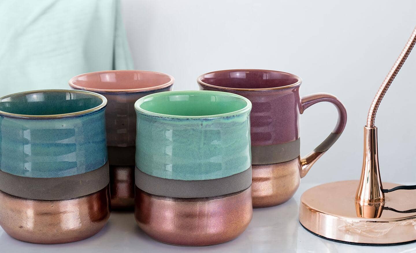 Four coffee mugs with comfort-grip handles sit in a group. Four coffee mugs with comfort-grip handles sit in a group.