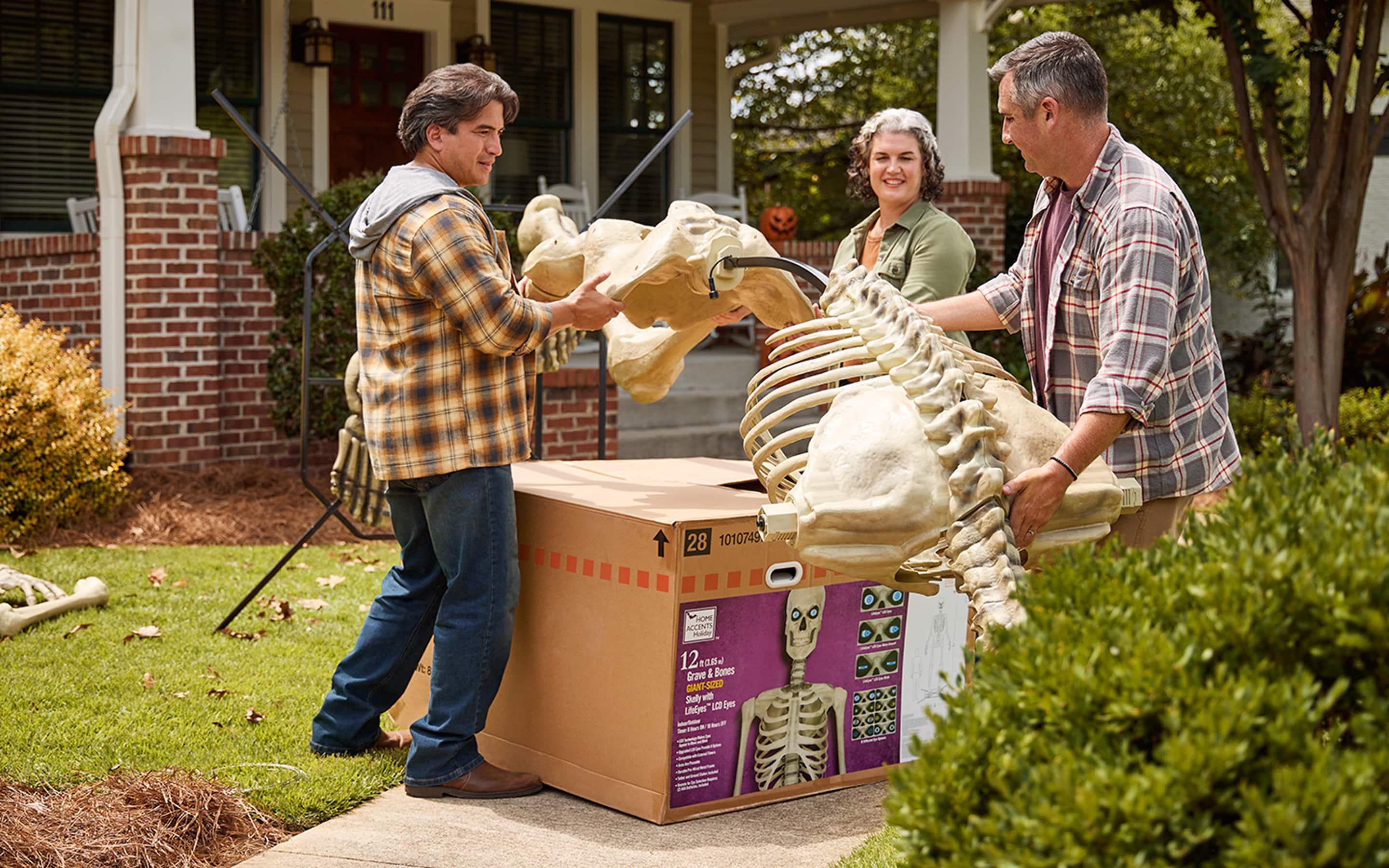 Homeowners packing a 12-foot skeleton back into its original box.