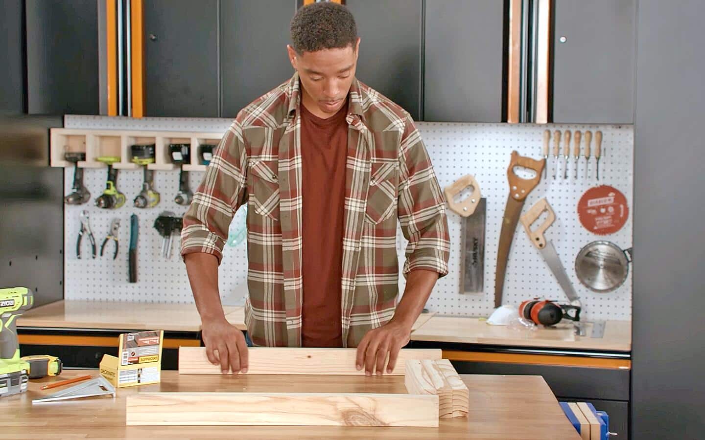 Someone setting up the wooden wall frame of a dog house.