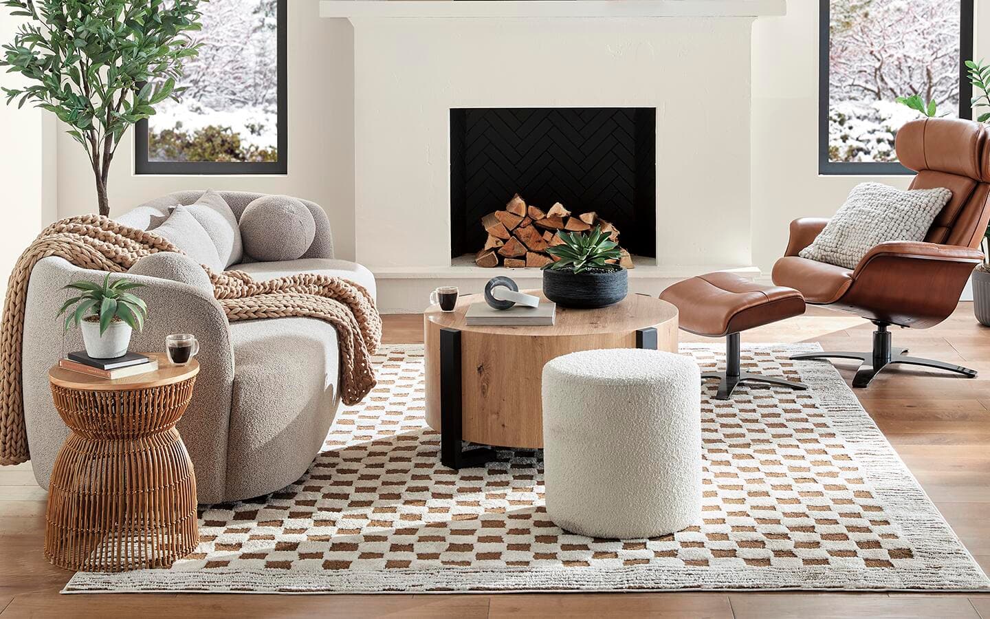 A living room space with a sofa, table and chairs accented with accessories like throw blankets, pillows and plants A living room space with a sofa, table and chairs accented with accessories like throw blankets, pillows and plants