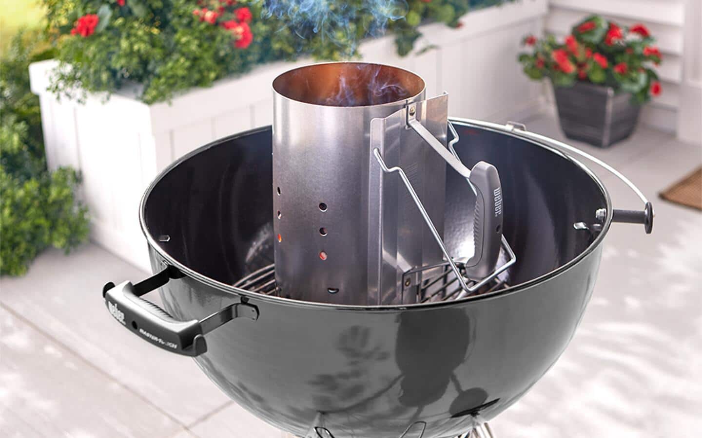 A charcoal chimney inside a charcoal barbecue grill. A charcoal chimney inside a charcoal barbecue grill.