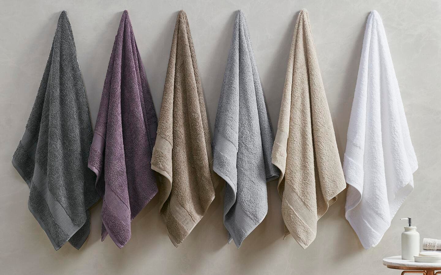 Towels of various colors hung on hooks in a bath. Towels of various colors hung on hooks in a bath.