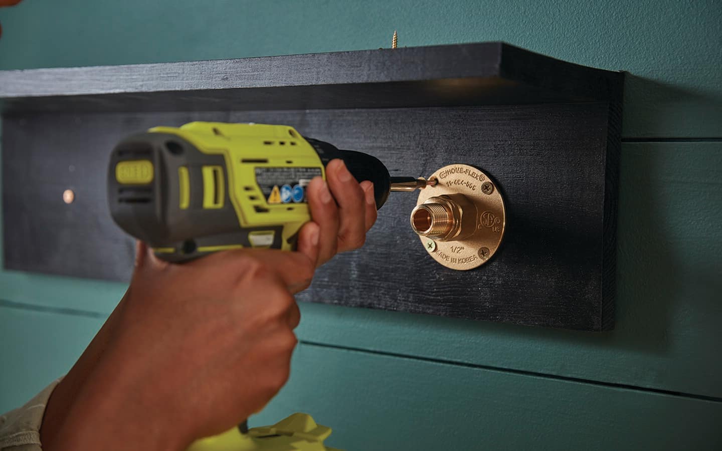 A person screws in the hanger on a coat rack.