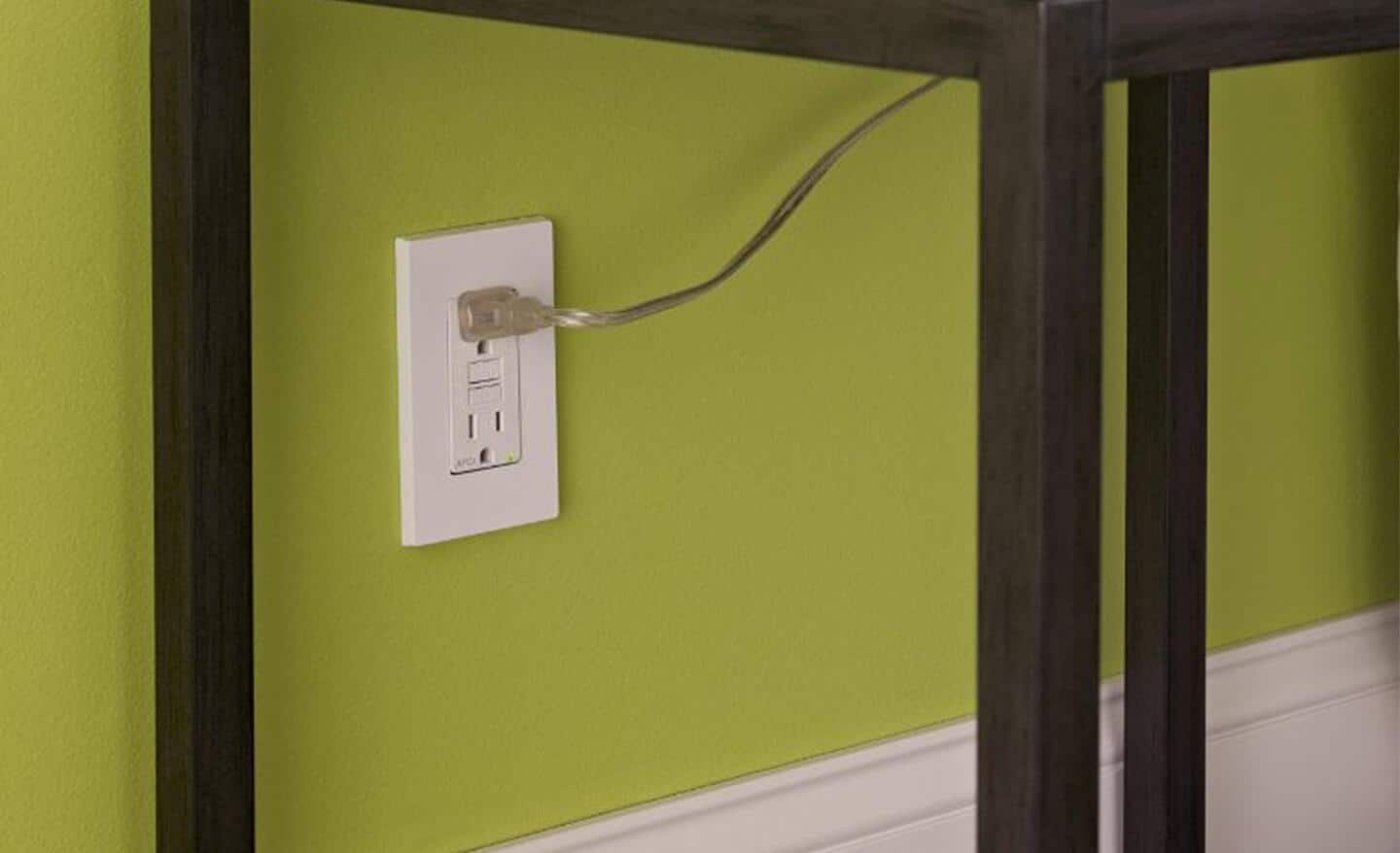 A lamp plugged into an AFCI outlet on a wall.