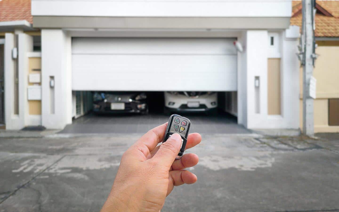 A person with a key fob opening a garage door.