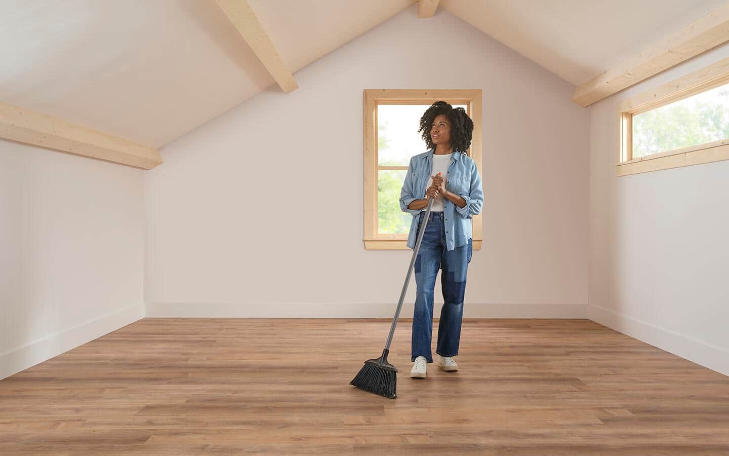 Woman preparing an empty attic space to be a new wellness room. Woman preparing an empty attic space to be a new wellness room.