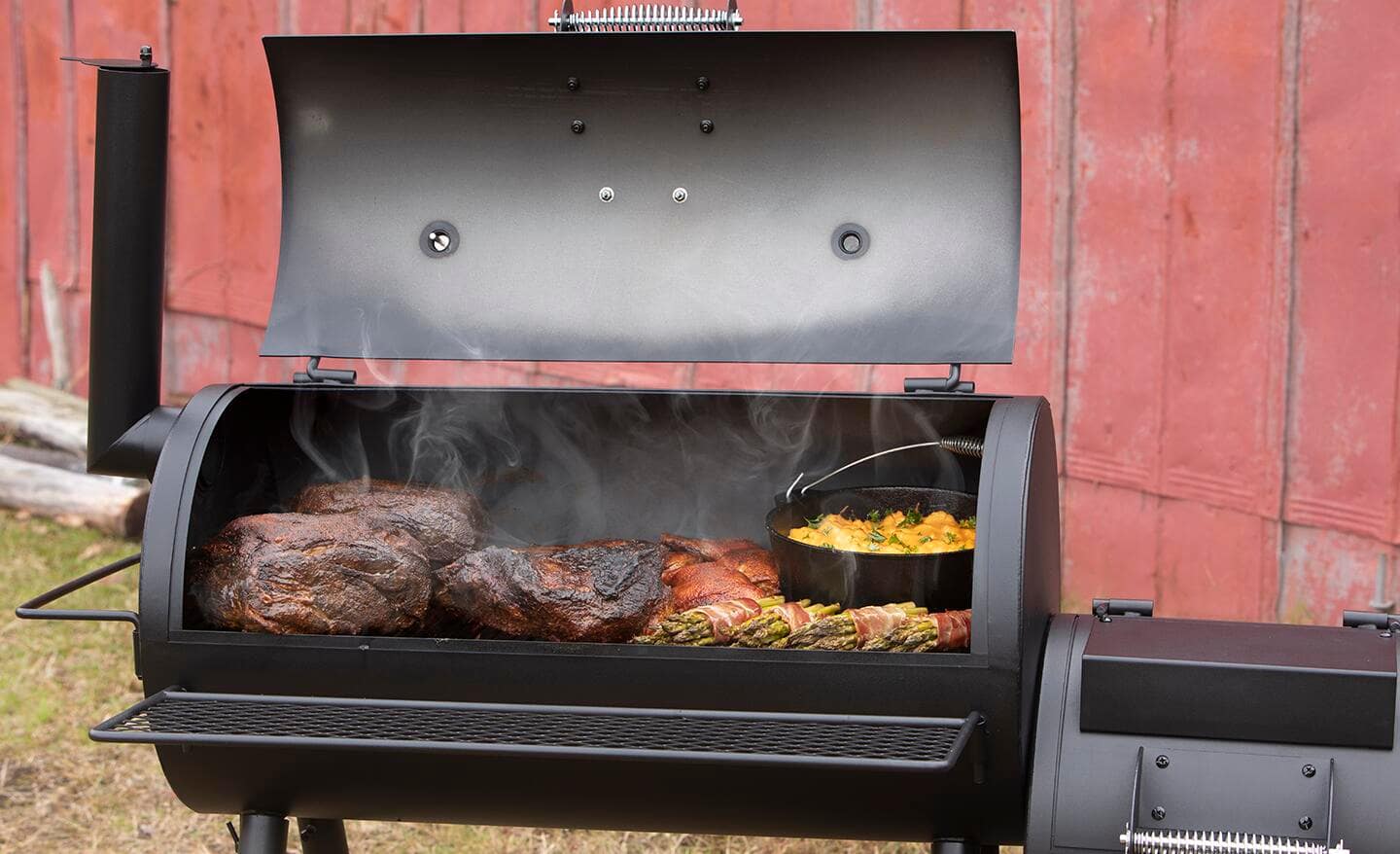 Meat and vegetables are cooked on a smoker grill.
