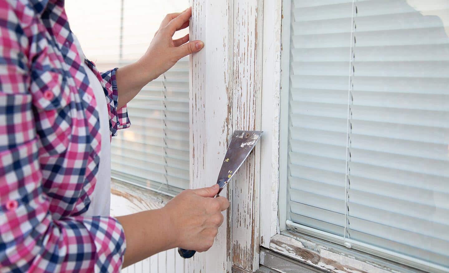 A person scraping off old paint. A person scraping off old paint.