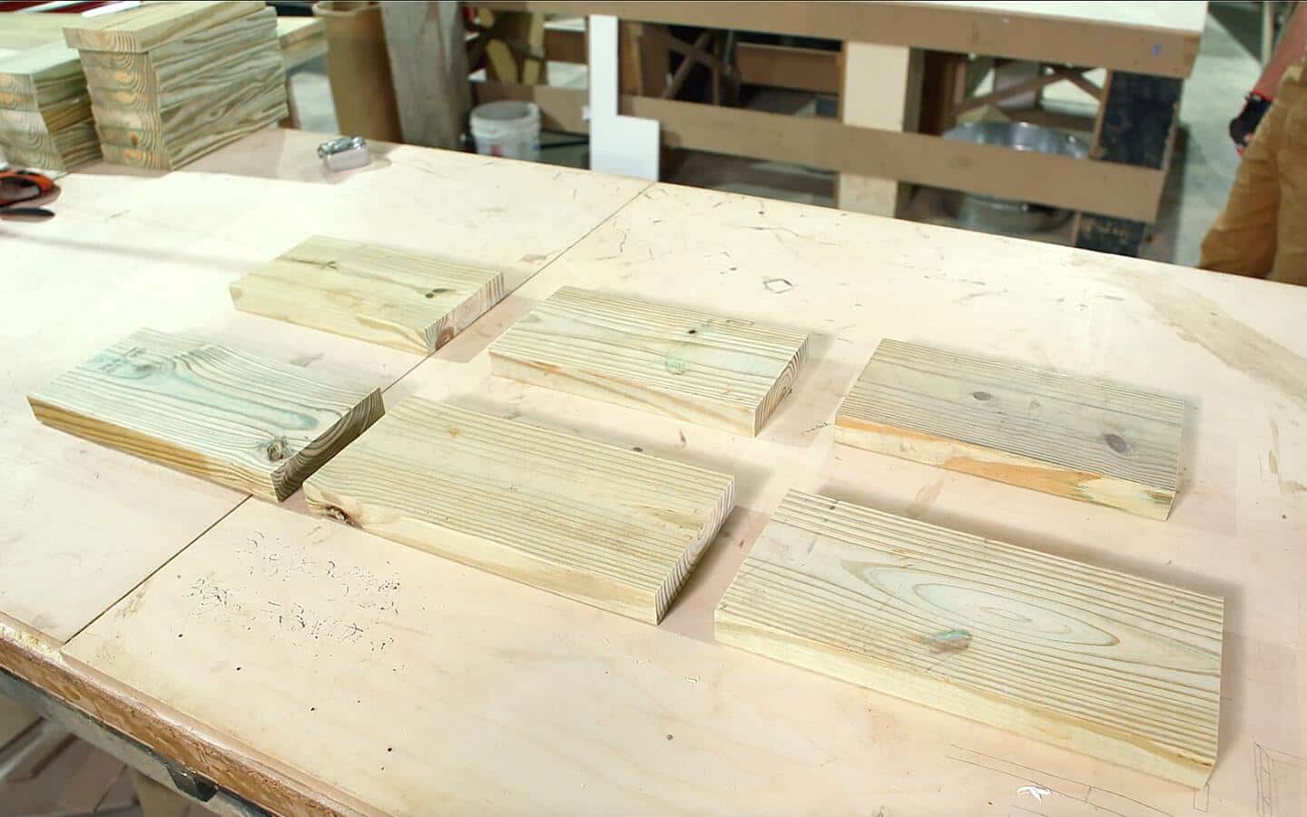 Multiple cuts of wood for an outdoor grill laid flat on a worktable.