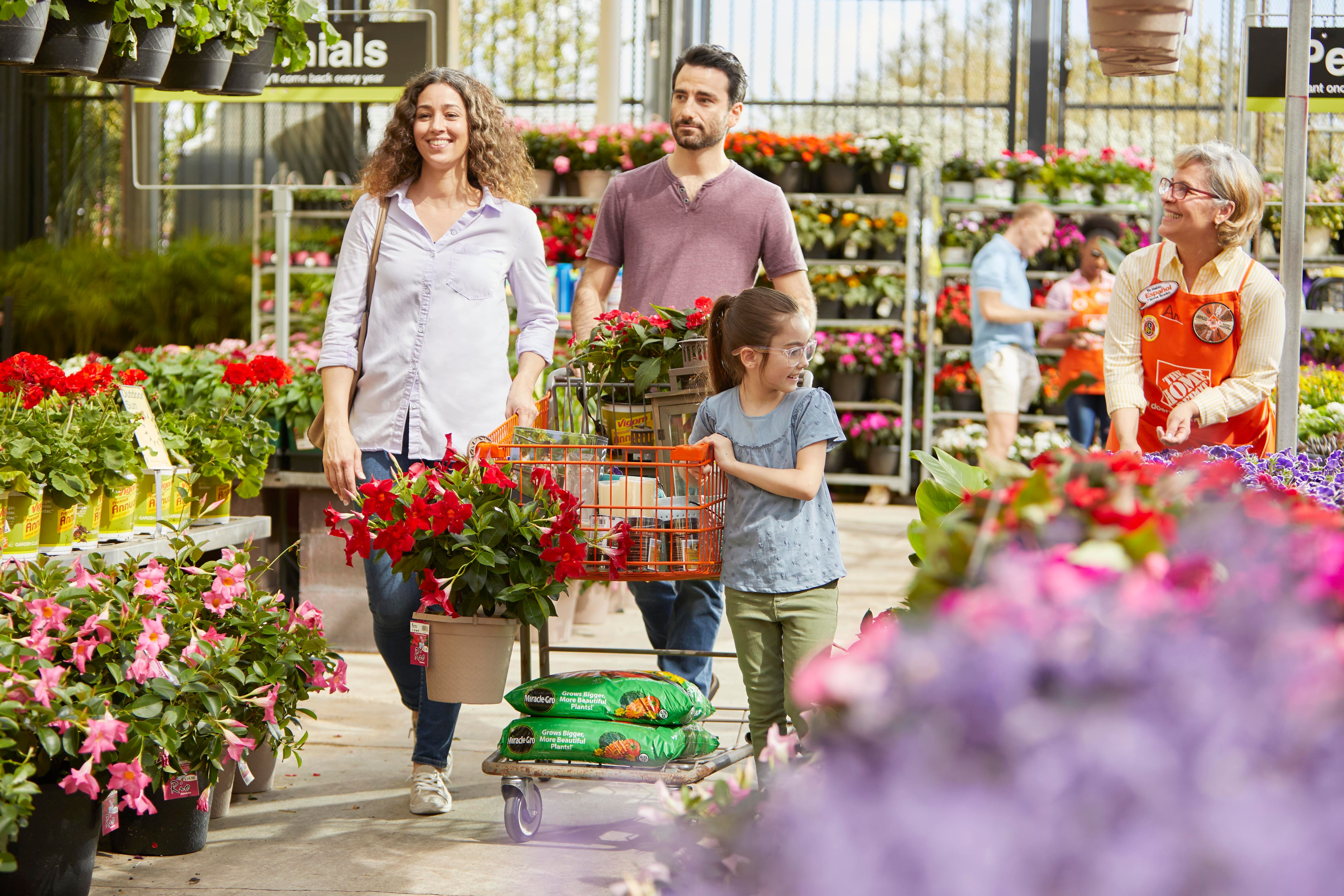 Parents and child shop the garden center as an associate looks on